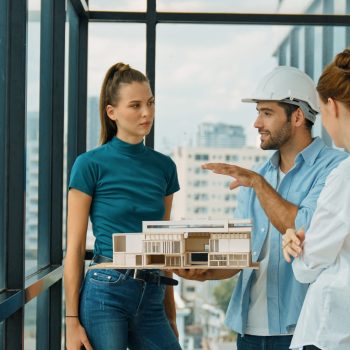Skilled engineer holds house model and explain about house construction to skilled manager. Group of interior designer inspect architectural model. Working together, Civil engineering. Tracery