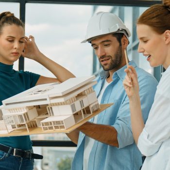 Skilled engineer holds house model and explain about house construction to skilled manager. Group of interior designer inspect architectural model. Working together, Civil engineering. Tracery